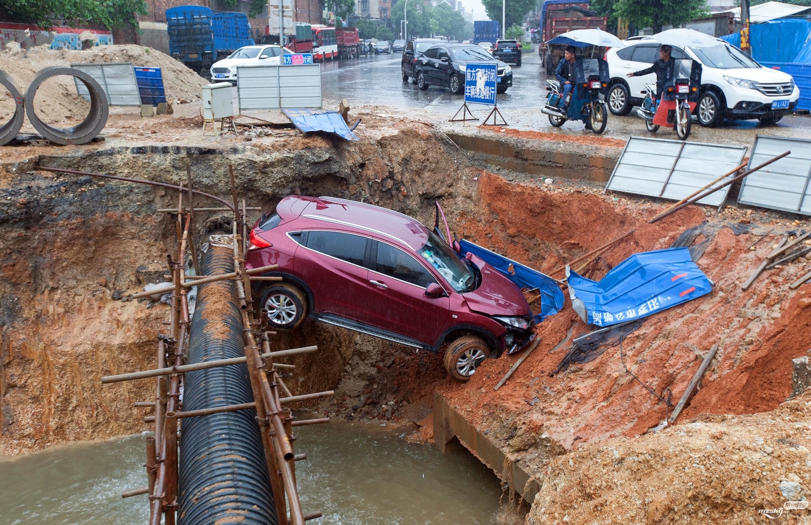 5月26日，湖南汨罗，一辆红色本田轿车撞毁工地警示墩后失控，栽进深坑。据了解，事故.jpg